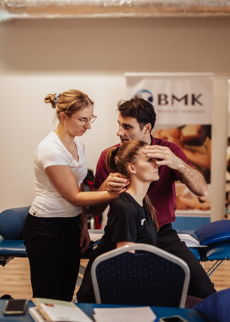 A physiotherapist teaches another physiology how to feel motion in the cervical spine.